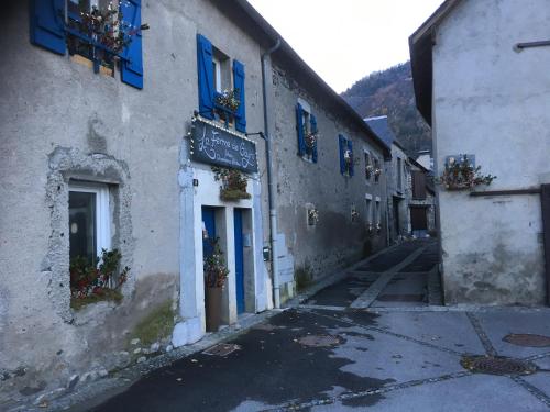 an alley with blue shutters on a building at La Ferme de Gayri, chalet d'exception avec sauna et jacuzzi à 5 minutes de St-Lary Soulan in Vielle-Aure