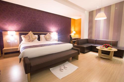 a hotel room with a bed and a couch at M Inn in Coimbatore
