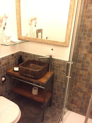a bathroom with a sink and a toilet and a mirror at Rio Groppo Guesthouse in Manarola