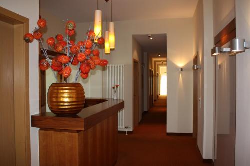 a hallway with a vase with red flowers in it at Pension Geno in Geisenhausen