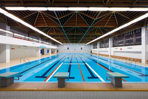 une grande piscine avec des couloirs bleus dans l'établissement Congress & Wellness Hotel Olsanka, à Prague