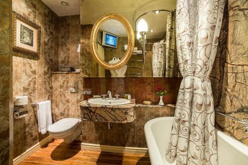 a bathroom with a tub and a sink and a toilet at Imperial Hotel & Restaurant in Vilnius