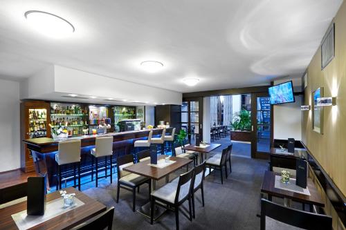 a restaurant with tables and chairs and a bar at Congress & Wellness Hotel Olsanka in Prague
