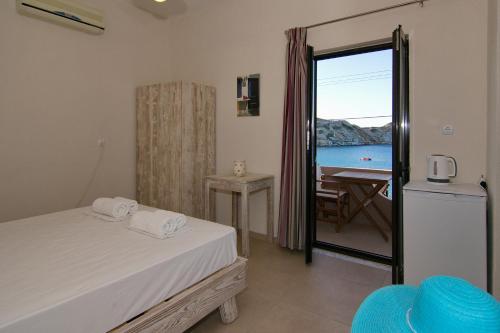 a bedroom with a bed and a view of the ocean at Lygaria Studios in Agia Pelagia
