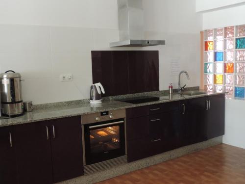 a kitchen with a stove and a fireplace at Albergue-Pensión Cabo da Vila in Finisterre