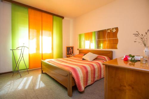 Schlafzimmer mit einem Bett mit regenbogenfarbenen Wänden in der Unterkunft Free Hugs in Mazzo di Valtellina