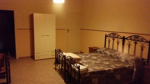 a bedroom with a bed and a dresser and a cabinet at Villa Laura Apartment in Giardini Naxos