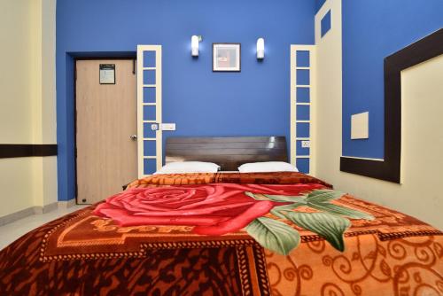 德拉敦Hotel Galaxy的蓝色墙壁间的一张床位
