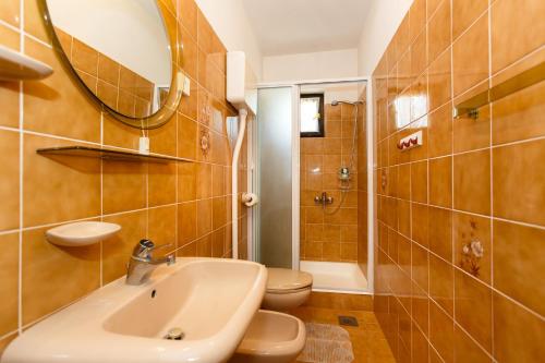 y baño con lavabo, aseo y espejo. en Villa Rosi, en Krk
