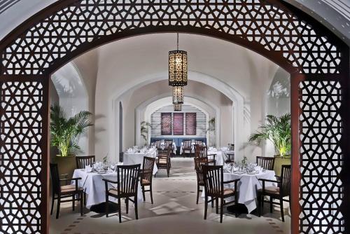 a dining room with tables and chairs and a chandelier at Steigenberger Alcazar in Sharm El Sheikh