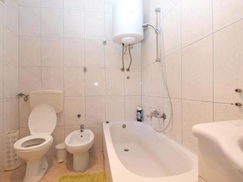 biała łazienka z toaletą i wanną w obiekcie Apartments Tereza 1352 w Puli