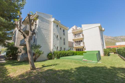 a building with a green lawn in front of a building at Apartamentos Massol in Port de Pollensa
