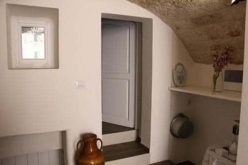um corredor com uma porta branca e uma janela em Palazzo Manfredi - Bed and Breakfast em Monopoli