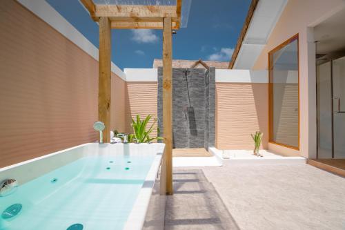 a bathroom with a tub in the middle of a house at Kudafushi Resort & Spa in Raa Atoll