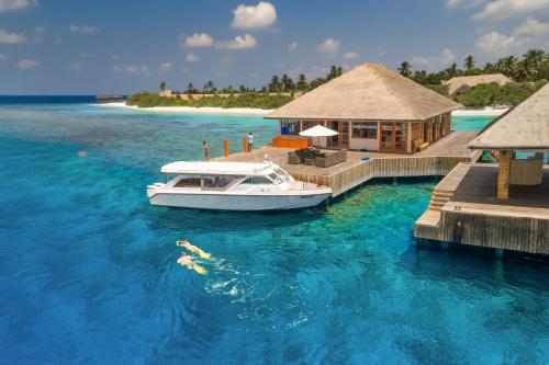 a boat is docked at a dock in the water at Kudafushi Resort & Spa in Raa Atoll