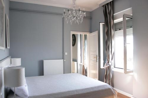a bedroom with a white bed and a chandelier at Apartments O la la in Zagreb
