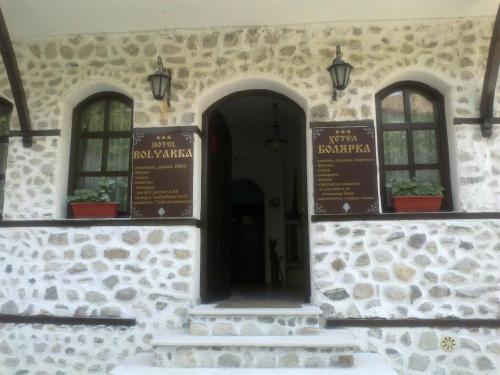 a building with three windows and a doorway at Hotel Bolyarka in Melnik