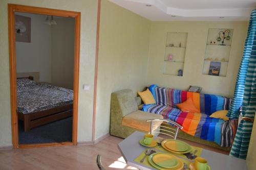 a living room with a couch and a bed at Catedra View Apartment in Ternopil