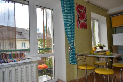 une cuisine avec une fenêtre et un comptoir avec des tabourets dans l'établissement Catedra View Apartment, à Ternopil