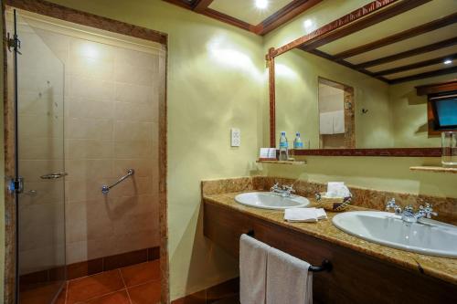y baño con 2 lavabos y ducha. en Ngorongoro Serena Safari Lodge en Ngorongoro