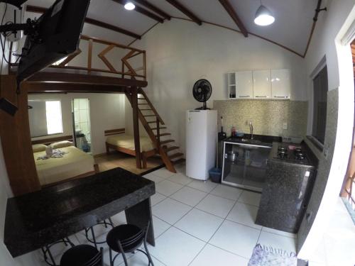 a kitchen with a room with a bed and a refrigerator at Recanto da Ilha in Abraão