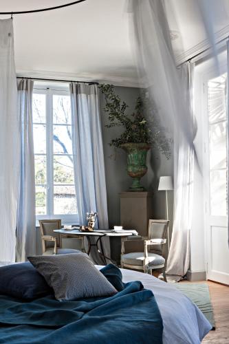 a bedroom with a bed and a table with chairs at La Divine Comédie-Suites Deluxe in Avignon