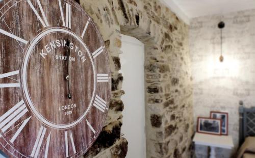 a large wooden clock on a stone wall at Dal Patriarca in Imperia