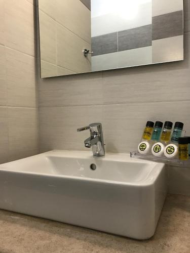 a white sink in a bathroom with a mirror at Pension Efie in Hydra