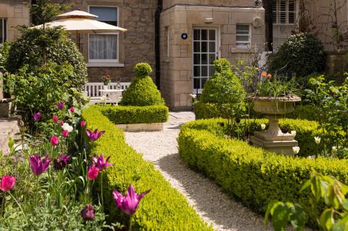 ein Garten vor einem Haus mit Blumen in der Unterkunft The Kennard Boutique Guesthouse in Bath