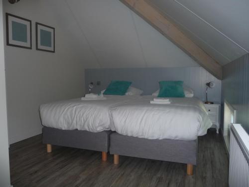 una camera da letto con un grande letto con cuscini verdi di Appelhoeve Logies a Loenen aan de Vecht