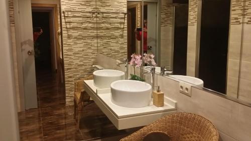 a bathroom with two sinks and a large mirror at Albergue Ultreia in Arzúa