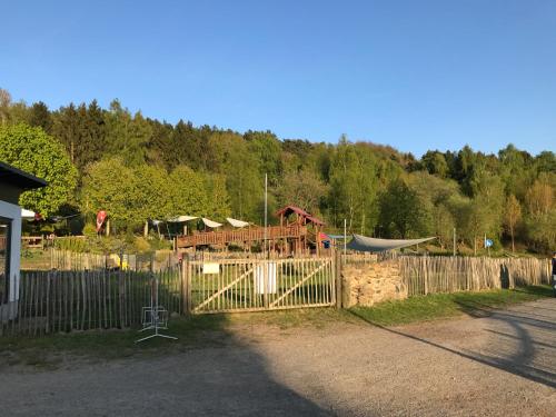 a fence with a playground in a yard at Ferienhaus Lilly am Silbersee in Frielendorf