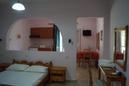 a bedroom with a bed and a table and a kitchen at Jason Rooms & Studios in Keratokampos
