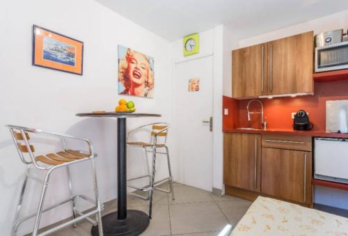 une cuisine avec une table et des tabourets dans une pièce dans l'établissement Pied à Terre en Ville, à Marseille