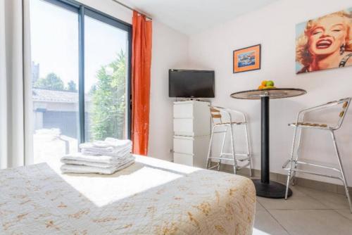 une chambre avec un lit, une table et une fenêtre dans l'établissement Pied à Terre en Ville, à Marseille