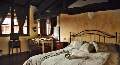 a bedroom with a large bed with a desk and a dining room at Agriturismo Bassanella in Treviglio