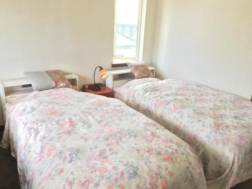 two beds sitting next to each other in a bedroom at Park Hills in Kitami