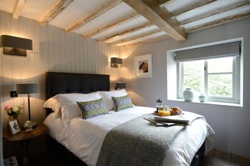sypialnia z dużym białym łóżkiem i oknem w obiekcie Walnut Cottage w mieście Moreton-in-Marsh