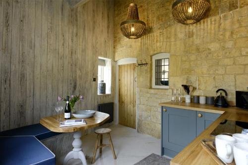 a kitchen with blue cabinets and a wooden wall at Walnut Cottage in Moreton in Marsh