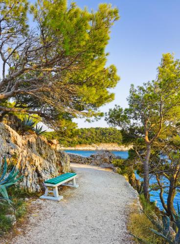 a bench sitting on a beach near the water at Apartment Mirna in Makarska