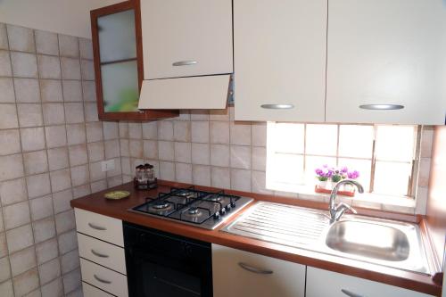 a kitchen with a stove top oven next to a sink at Appartamenti Greso in Custonaci