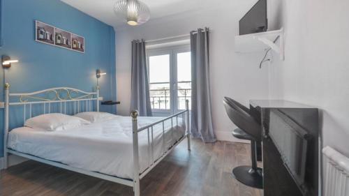 une chambre avec un lit avec un mur bleu dans l'établissement Brasserie Michel / Cesar Hotel, à Le Portel