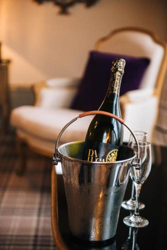 a bottle of champagne in a bucket on a table at Lynnhurst Hotel in Johnstone