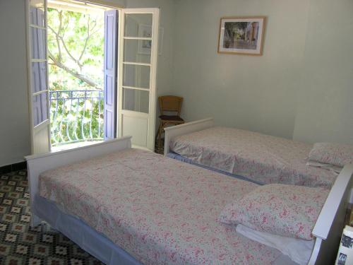 two beds in a room with a window at Mas de la Riviere in Villelongue-de-la-Salanque