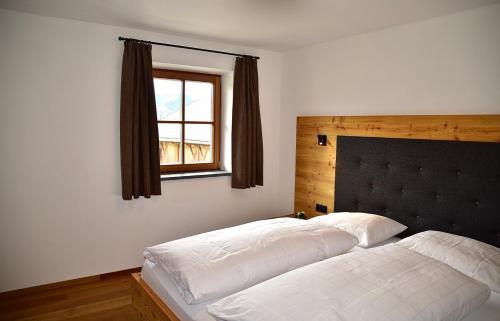 a bedroom with two white beds and a window at Putzerhof in Funes