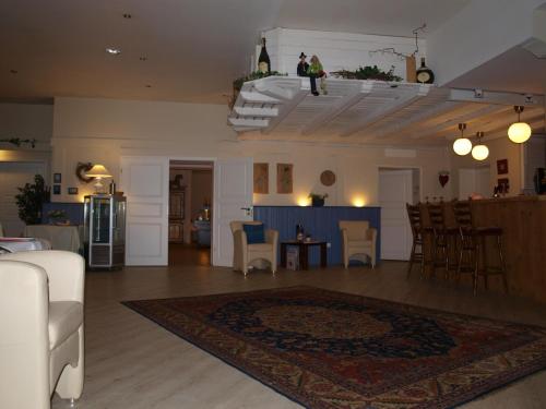 a living room with a couch and a table and chairs at Landhaus Pfahlershof in Karolinenkoog