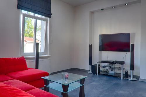 a living room with a red couch and a tv at Apartament Sto Metrów Od Morza in Świnoujście