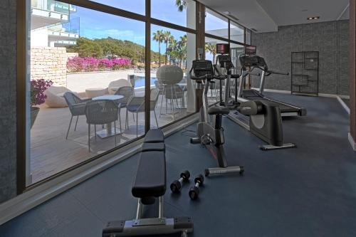 a gym with treadmills and ellipticals in a room at Catalonia Royal Ses Estaques-Adults Only in Santa Eularia des Riu