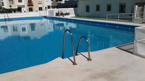 una piscina de agua azul en un edificio en Apartamentos Tursol, en Nerja