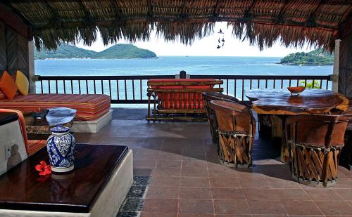 a room with a balcony with a view of the ocean at Hotel Aura del Mar in Zihuatanejo